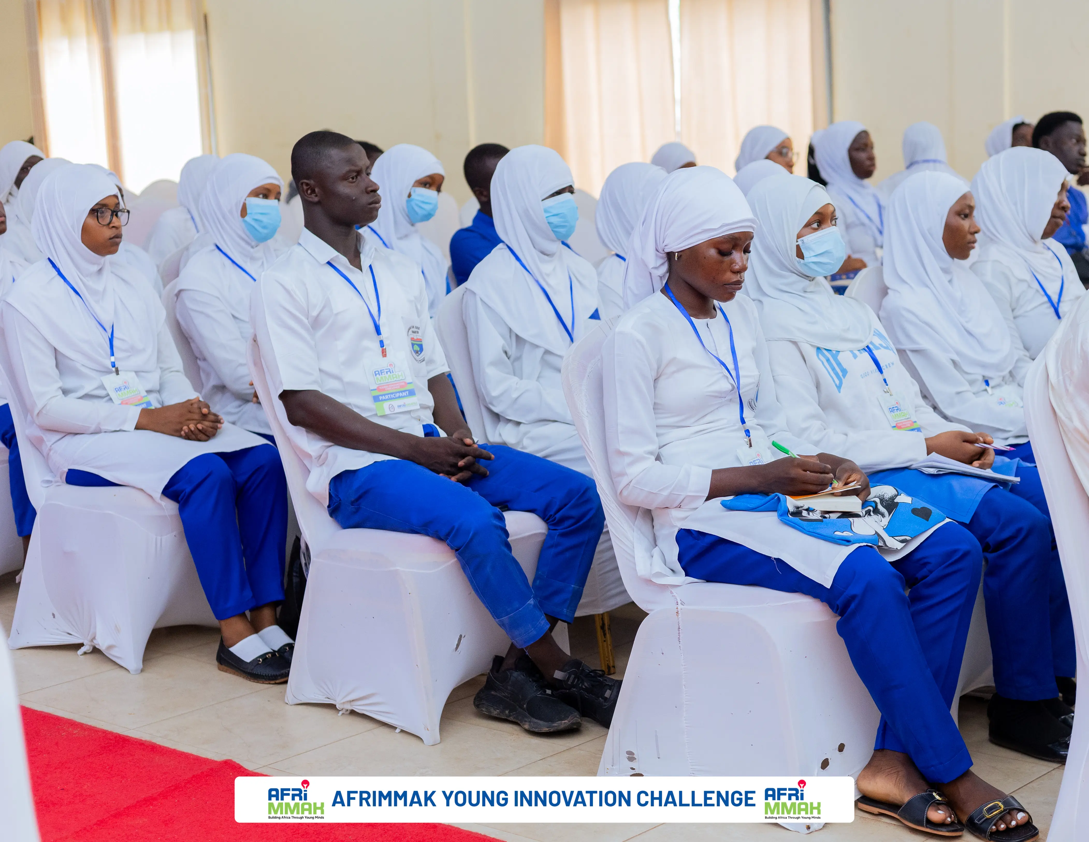 Young students seated together in a hall during a schools event